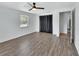 This bedroom has wood-look floors, neutral paint, a window, closet with curtains, and a ceiling fan at 636 W Mathis St, Deland, FL 32720