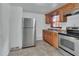 Traditional kitchen with stainless steel refrigerator and stove, wood cabinets, and tile flooring at 636 W Mathis St, Deland, FL 32720