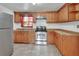 Bright kitchen featuring stainless steel appliances, warm wood cabinets, and tile floors at 636 W Mathis St, Deland, FL 32720