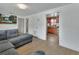 Comfortable living room with gray sectional, TV, and a view into the kitchen and hallway at 636 W Mathis St, Deland, FL 32720