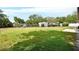 Expansive backyard featuring lush green grass, mature trees, and a storage shed at 672 Swarthmore Dr, Deland, FL 32724