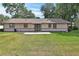 Back of house with nice patio, spacious grassy yard, and mature landscaping at 672 Swarthmore Dr, Deland, FL 32724