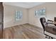 Bedroom featuring wood-look flooring, large windows, and a chair with workstation at 672 Swarthmore Dr, Deland, FL 32724