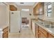Galley kitchen featuring wood cabinets, stainless steel sink, and white appliances at 672 Swarthmore Dr, Deland, FL 32724