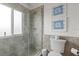 Modern bathroom with glass-enclosed shower, tiled walls, and charming coastal artwork at 6847 S Atlantic Ave, New Smyrna Beach, FL 32169