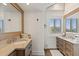 Elegant bathroom featuring double sinks, granite countertops, and a bright window with natural light at 6847 S Atlantic Ave, New Smyrna Beach, FL 32169