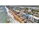 An aerial view showcases charming beachfront homes lining the shore with ocean views and private beach access at 6847 S Atlantic Ave, New Smyrna Beach, FL 32169