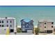 A beautiful two-story beach house with a blue roof, dolphin art, and stairs to the beach at 6847 S Atlantic Ave, New Smyrna Beach, FL 32169