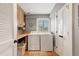 Bright laundry room with full-size washer and dryer, folding counter, storage cabinet, and ample storage space at 6847 S Atlantic Ave, New Smyrna Beach, FL 32169