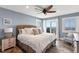 Relaxing primary bedroom featuring a beachy feel with a rattan headboard, ceiling fan, and a private balcony overlooking ocean at 6847 S Atlantic Ave, New Smyrna Beach, FL 32169