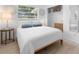 Cozy bedroom features a comfortable bed, wood floors, and natural light at 708 Wayne Ave, New Smyrna Beach, FL 32168