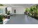 Spacious covered patio with seating, plants, and dual doors, perfect for outdoor entertaining at 708 Wayne Ave, New Smyrna Beach, FL 32168