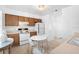 Well-lit kitchen with white appliances, wooden cabinets, and a small dining table at 708 Wayne Ave, New Smyrna Beach, FL 32168