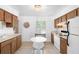 Functional kitchen features wood cabinets, white appliances, and a cozy dining area at 708 Wayne Ave, New Smyrna Beach, FL 32168