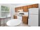 Bright kitchen with white appliances, wooden cabinets, and a charming breakfast nook at 708 Wayne Ave, New Smyrna Beach, FL 32168