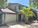 Charming townhome featuring an attached garage and a lovely palm tree in the front yard at 805 N Clake St, Deland, FL 32724