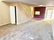 Open living area with carpeted floors, a staircase, and access to the entry foyer at 805 N Clake St, Deland, FL 32724