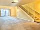 A bright living room features sliding glass doors and carpeted stairs leading to the second floor at 805 N Clake St, Deland, FL 32724
