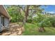 Large, private backyard with mature trees and lush tropical landscaping and a patio at 88 Valencia Dr, Ormond Beach, FL 32176