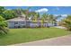 Charming single-story home featuring a well-maintained lawn, palm trees, and a classic concrete block privacy screen at 88 Valencia Dr, Ormond Beach, FL 32176