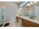 Bright bathroom featuring a double vanity, large mirror, and glass-enclosed shower at 887 Lake Hill Way, Deland, FL 32724