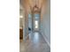 Hallway with a high ceiling with an ornate lighting fixture leading to the front door and a partial view of the bathroom at 887 Lake Hill Way, Deland, FL 32724