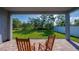 Covered patio with stone pavers and rocking chairs overlooking a green backyard at 887 Lake Hill Way, Deland, FL 32724