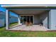 Covered patio with stone pavers, rocking chairs, and outdoor grill at 887 Lake Hill Way, Deland, FL 32724
