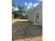 A backyard with dry grass and the side of a home with a sliding door at 926 Clover St, Deland, FL 32720