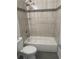 Bathroom with tub and shower, toilet and neutral-toned tiling at 926 Clover St, Deland, FL 32720