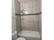 Bright bathroom featuring a tub with shower and neutral-toned tiling at 926 Clover St, Deland, FL 32720
