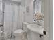 Bathroom featuring a pedestal sink, framed mirror and tiled shower with leaf-patterned curtain at 1075 Burgoyne Rd, Deland, FL 32720