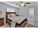 The bedroom features a ceiling fan, plush bed, and en-suite bathroom at 1075 Burgoyne Rd, Deland, FL 32720