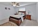 The bedroom features a ceiling fan, plush bed, and neutral decor at 1075 Burgoyne Rd, Deland, FL 32720