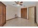 Bedroom with tile floor, ceiling fan, and brown closet doors at 1075 Burgoyne Rd, Deland, FL 32720