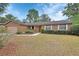 Beautiful brick home featuring manicured front lawn, well-maintained landscaping, and bright white window shutters at 1075 Burgoyne Rd, Deland, FL 32720