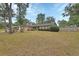 Brick home featuring a manicured lawn and mature shade trees at 1075 Burgoyne Rd, Deland, FL 32720