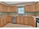 Kitchen features light wood cabinets, tile countertops, and stainless dishwasher at 1075 Burgoyne Rd, Deland, FL 32720