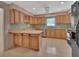 Kitchen features light wood cabinets, tile countertops, and modern appliances at 1075 Burgoyne Rd, Deland, FL 32720