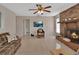 Spacious living room featuring neutral tile flooring, brick fireplace, and an entertainment center at 1075 Burgoyne Rd, Deland, FL 32720