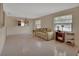 Bright living room with neutral tile flooring, multiple windows, and a chandelier at 1075 Burgoyne Rd, Deland, FL 32720