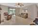 Comfortable living room featuring neutral tile flooring and sliding glass door to the outside at 1075 Burgoyne Rd, Deland, FL 32720