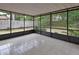 Spacious screened porch with neutral tile flooring and dark accents provides backyard views at 1075 Burgoyne Rd, Deland, FL 32720