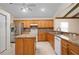 Kitchen boasts stainless steel appliances, tile floors and backsplash, and wood cabinets at 11094 Se 173Rd Ln, Summerfield, FL 34491