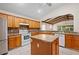 Bright kitchen features an island, tile floors and backsplash, and white appliances at 11094 Se 173Rd Ln, Summerfield, FL 34491