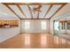 Open living room with wood beam ceiling and sliding glass door to the back porch at 11094 Se 173Rd Ln, Summerfield, FL 34491
