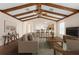 Spacious, staged living room featuring wood beam ceiling, ceiling fan, and view to kitchen at 11094 Se 173Rd Ln, Summerfield, FL 34491