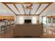 Staged living room featuring wood beam ceiling, ceiling fan, and sliding glass door to porch at 11094 Se 173Rd Ln, Summerfield, FL 34491