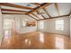 Open living room, wood beam ceiling, adjacent to kitchen, and rich flooring at 11094 Se 173Rd Ln, Summerfield, FL 34491