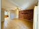 Inviting living room featuring brick accent wall, tile flooring, ceiling fan, and convenient kitchen access at 1120 Arden St, Longwood, FL 32750
